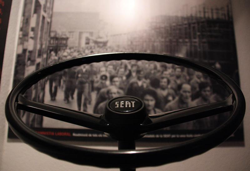 Wheel of a SEAT 600 and a 1977 photo of SEAT workers