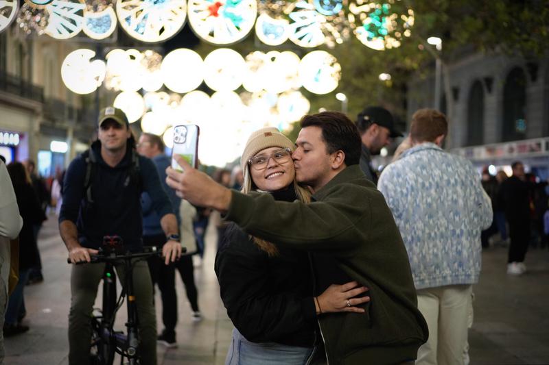 Couple taking a selfie in front of Barcelona's Christmas lights