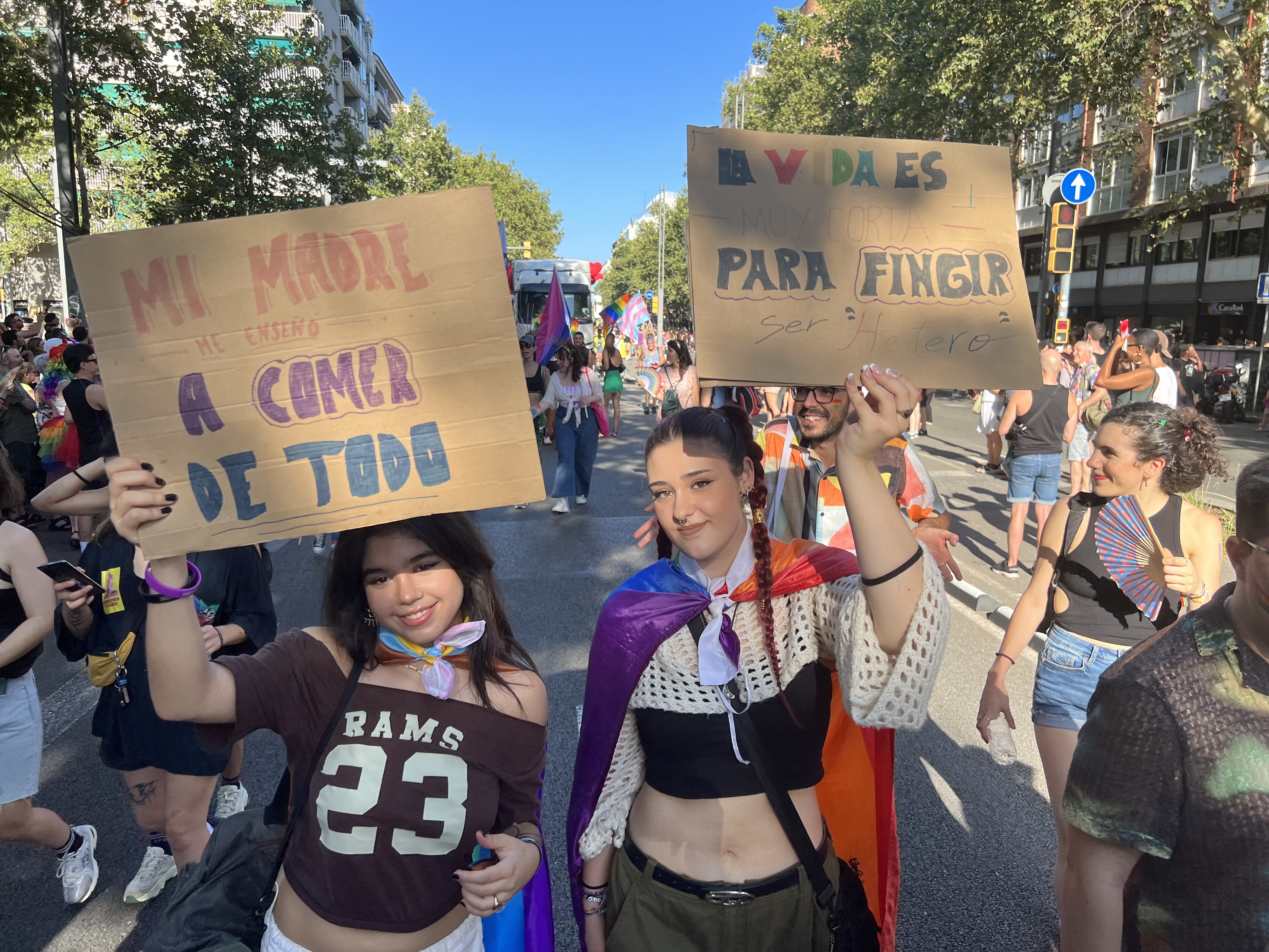 Two young people show protest banners during Pride Barcelona