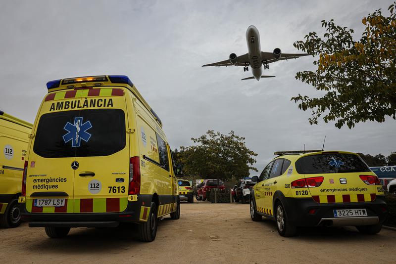Medical emergency vehicles, including an ambulance, parked beside Barcelona's airport during an air crash simulation in a wetland area on November 21, 2022