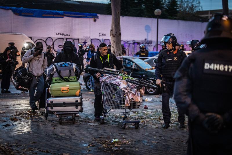 People who had been living in B9 carry their belongings leaving the site