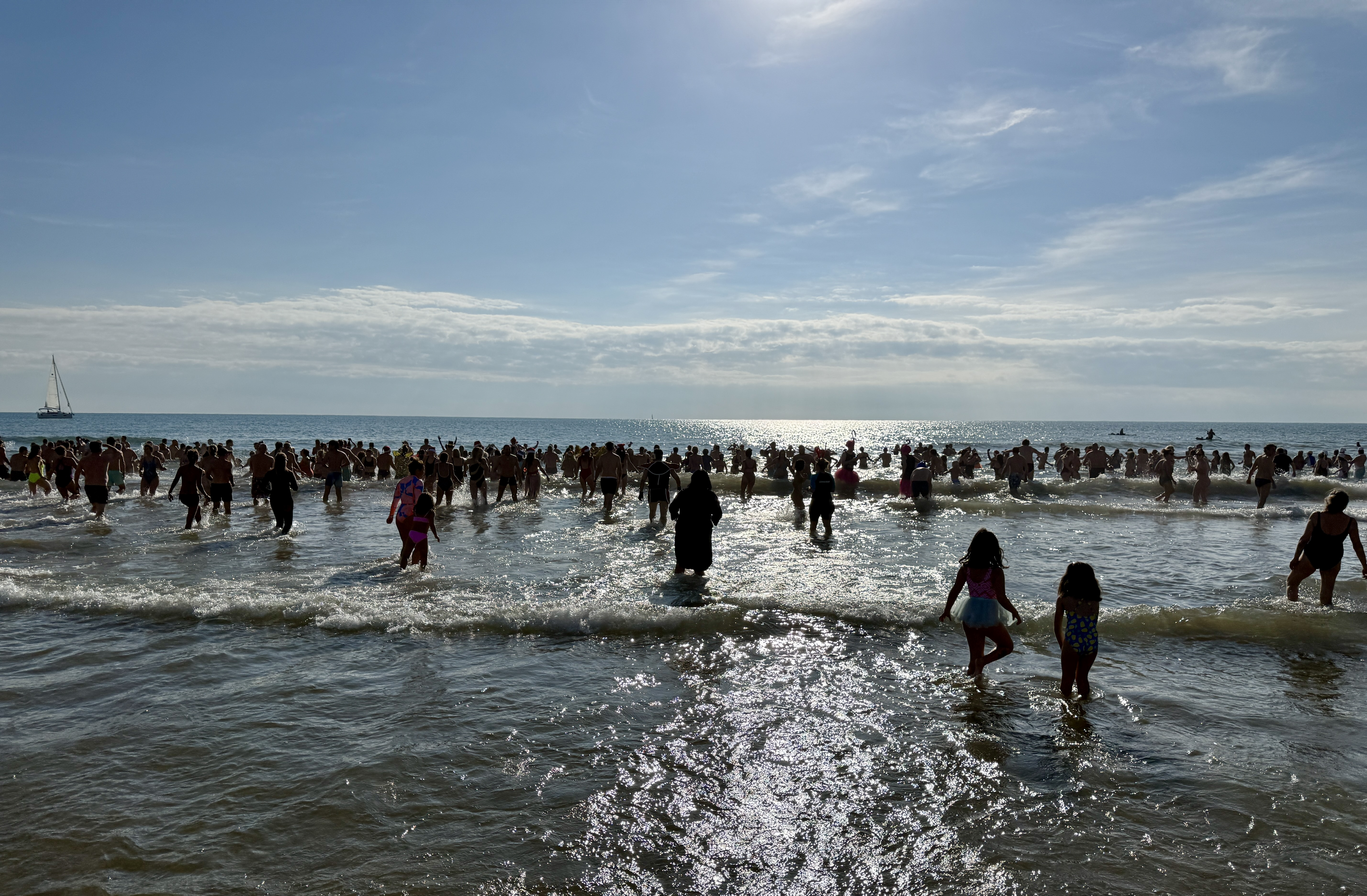 Centenars de persones es banyen a la platja de Sant Sebastià de Sitges per donar la benvinguda al 2026.