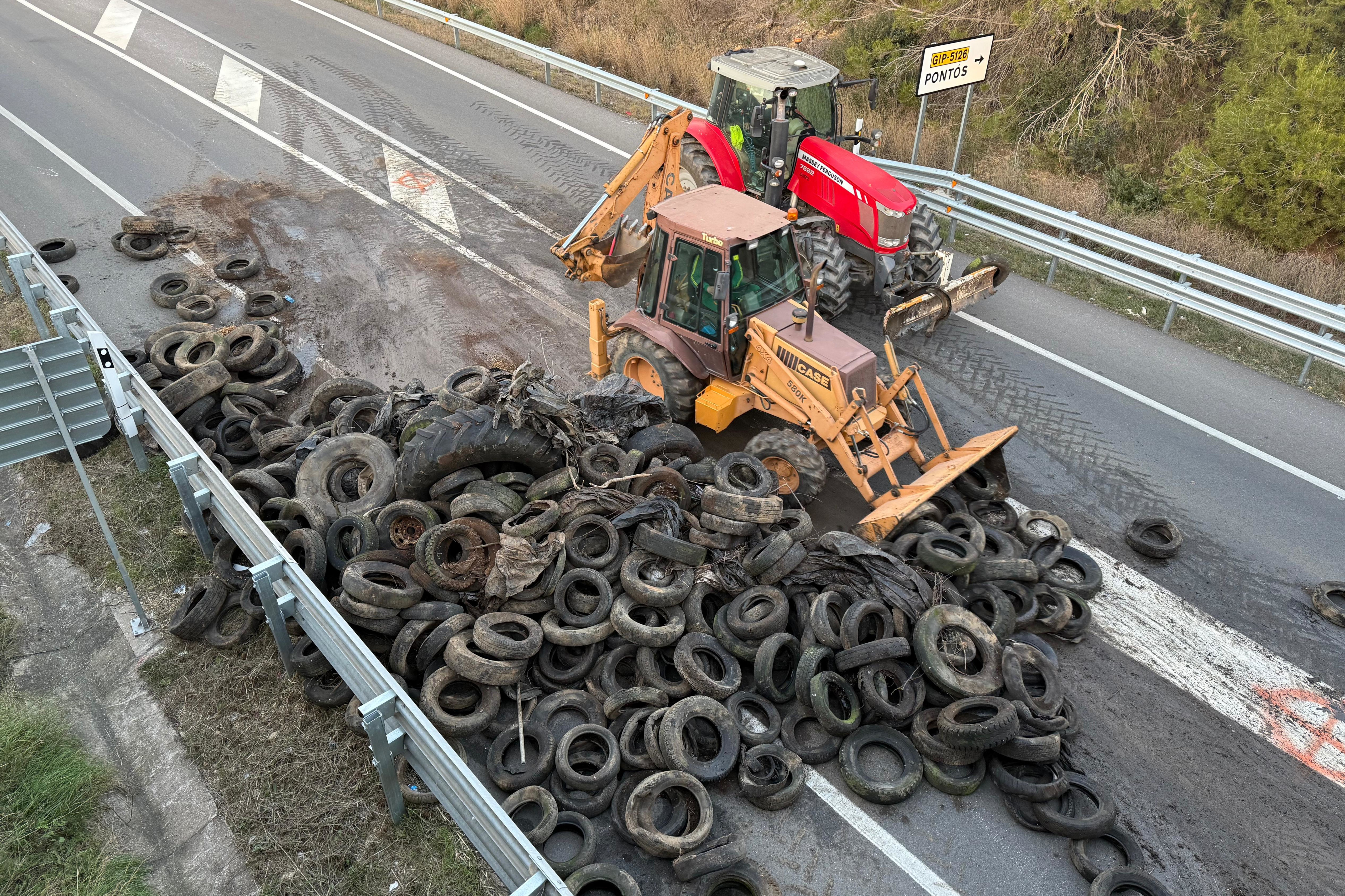 A tractor removes dozens of tires from the N-II national highway on January 8, 2026 during a protest against the Mercosur deal