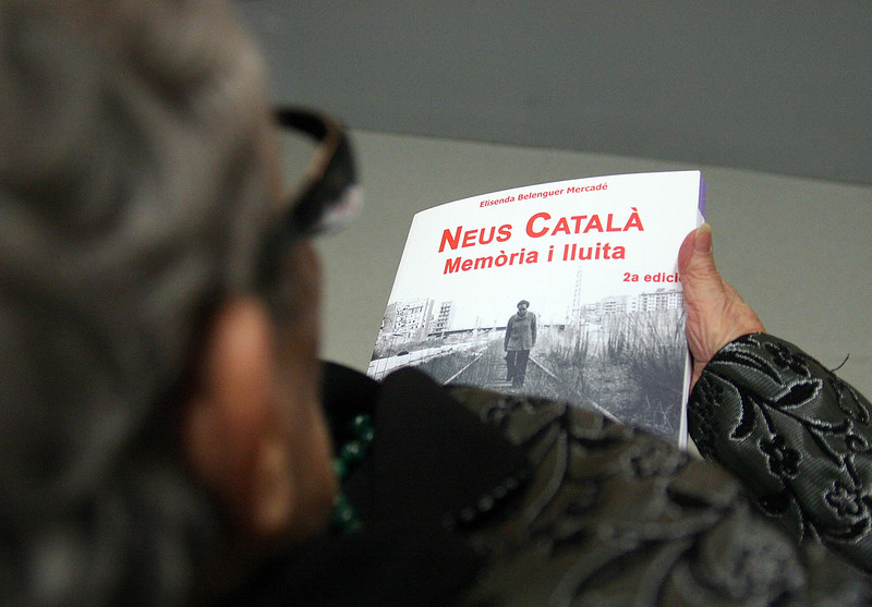 Neus Català holds a copy of her biography, 'Neus Català, Memory and Struggle', written by Elisenda Belenguer Mercadé
