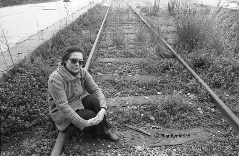 Neus Català poses at train tracks at Estació de França in Barcelona in a professional portrait following her return to Catalonia