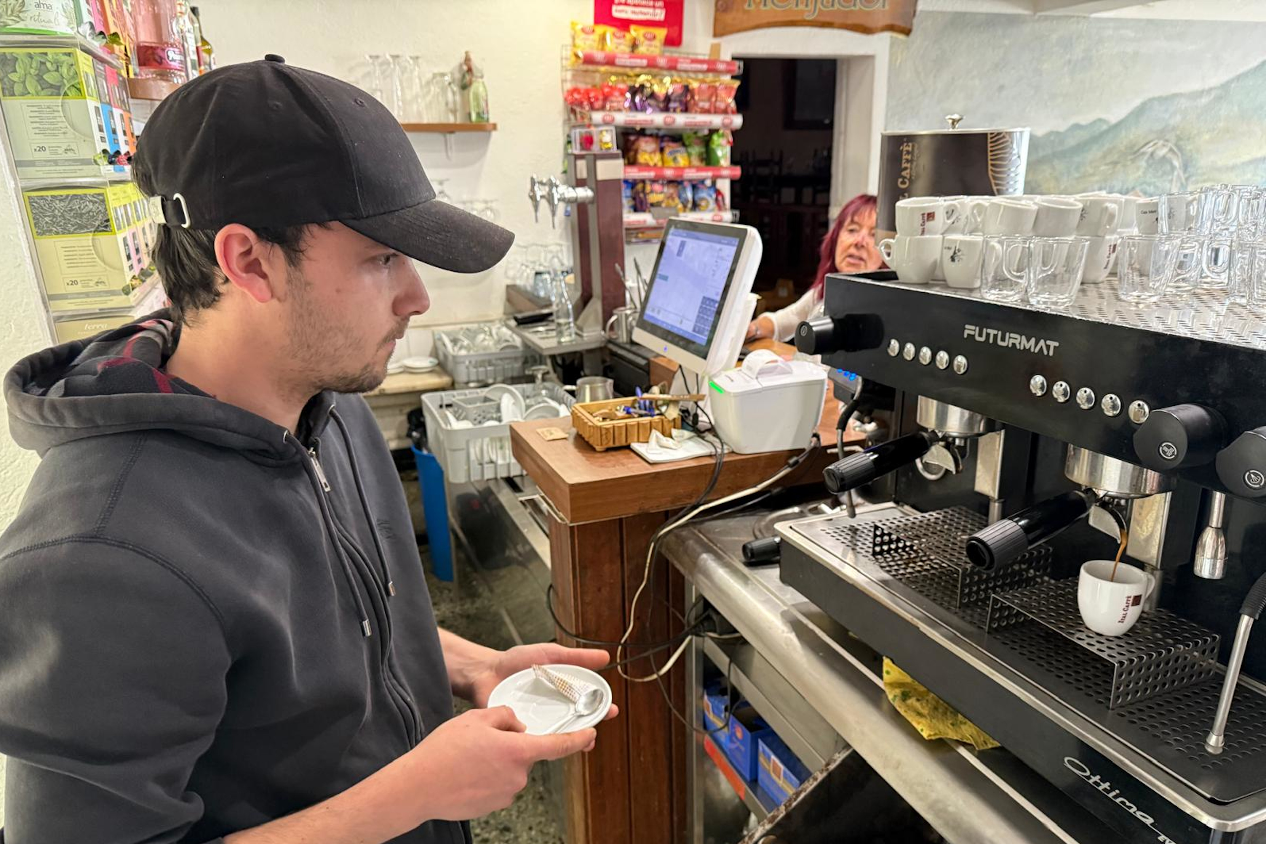 A staff member in a bar makes a coffee