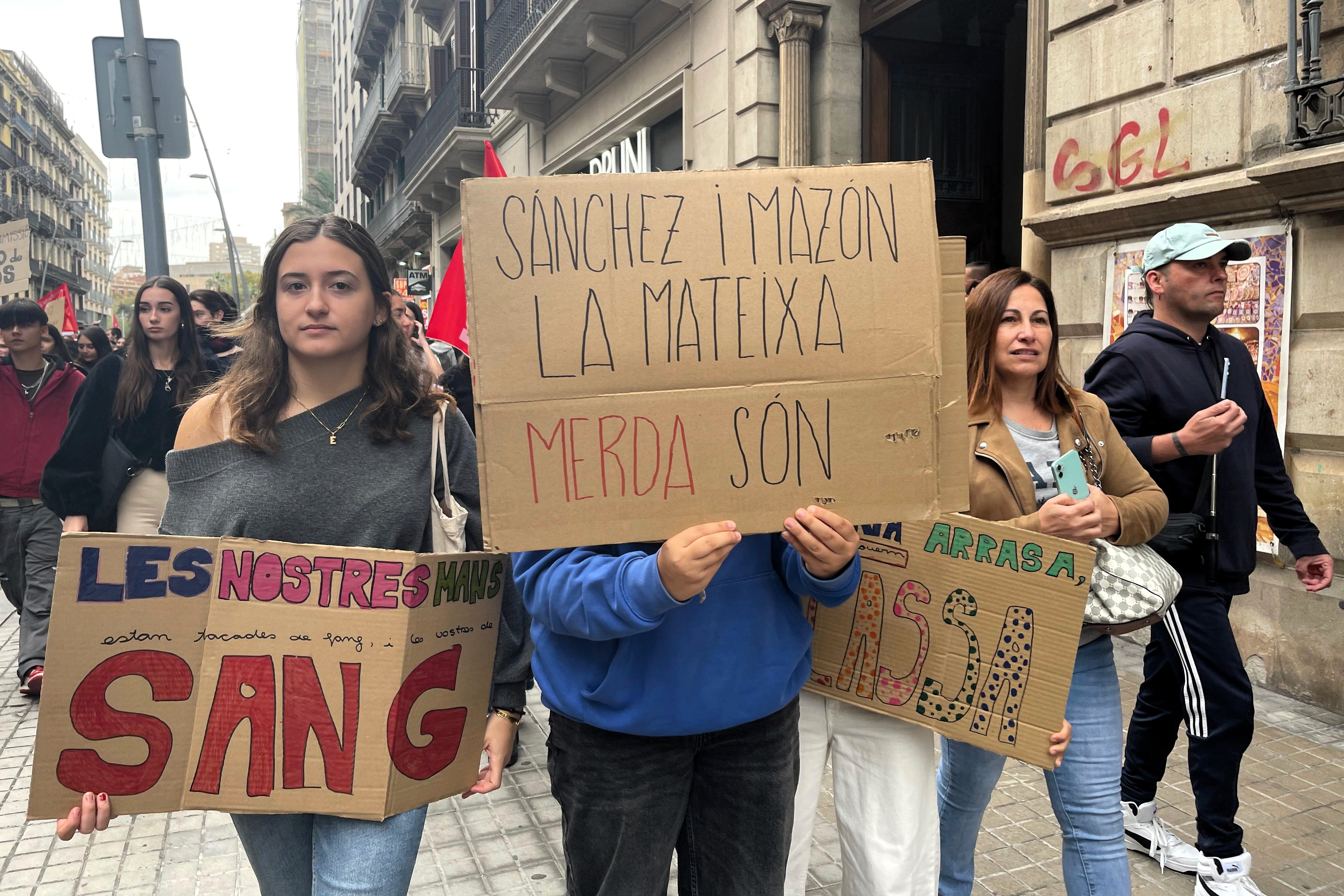 Students carry a poster reading 'Spanish PM Sánchez and Valencian president Carlos Mazón are both useless' during a demonstration in Barcelona over the handling of the Valencian floods on November 12, 2024