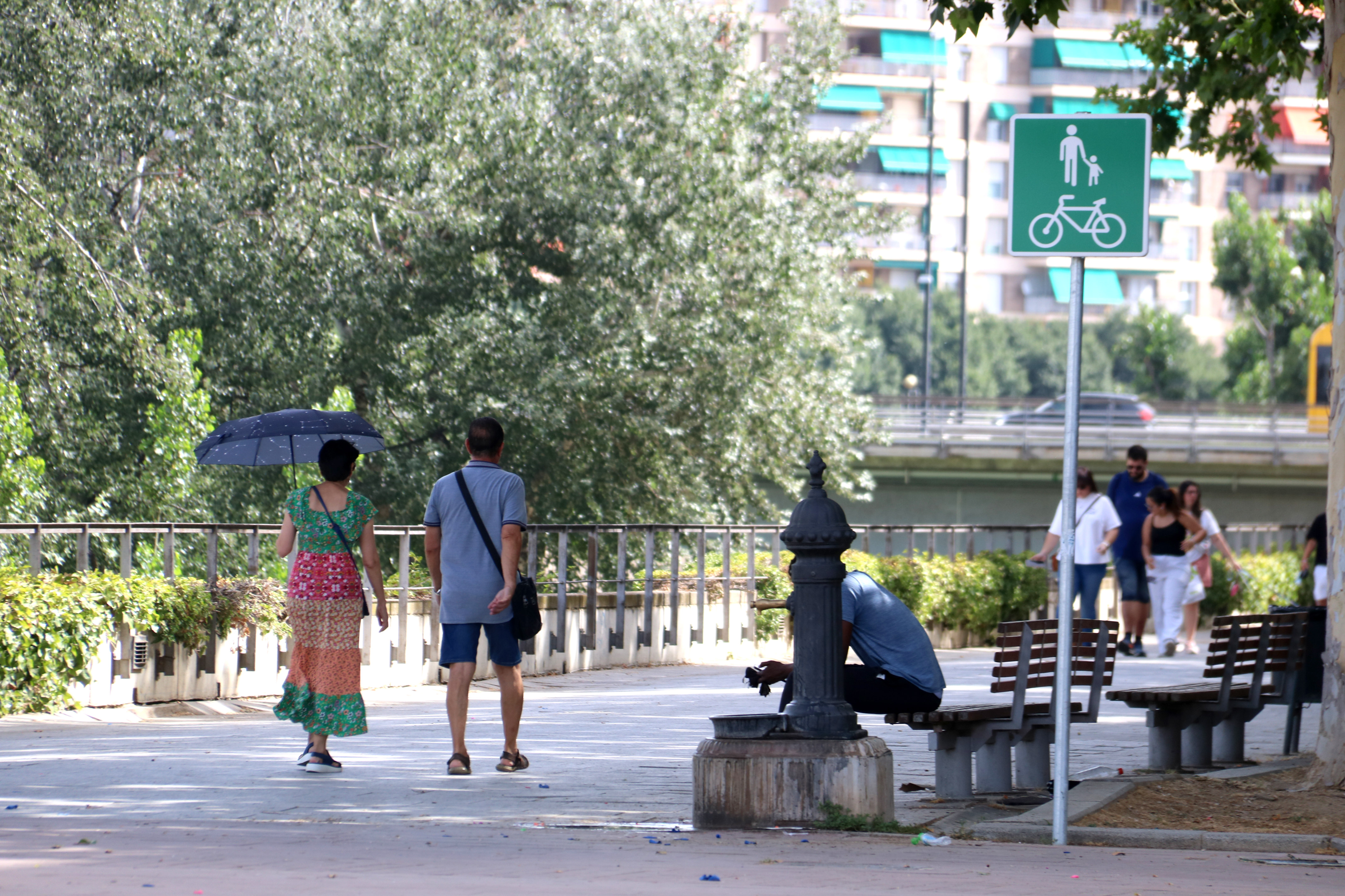 A woman walks with an umbrella to protect herself from the sun during the first day of a heat wave in Lleida
