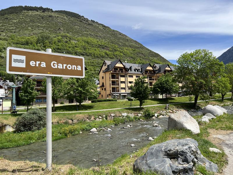 Garona river with a sign written in Aranese language