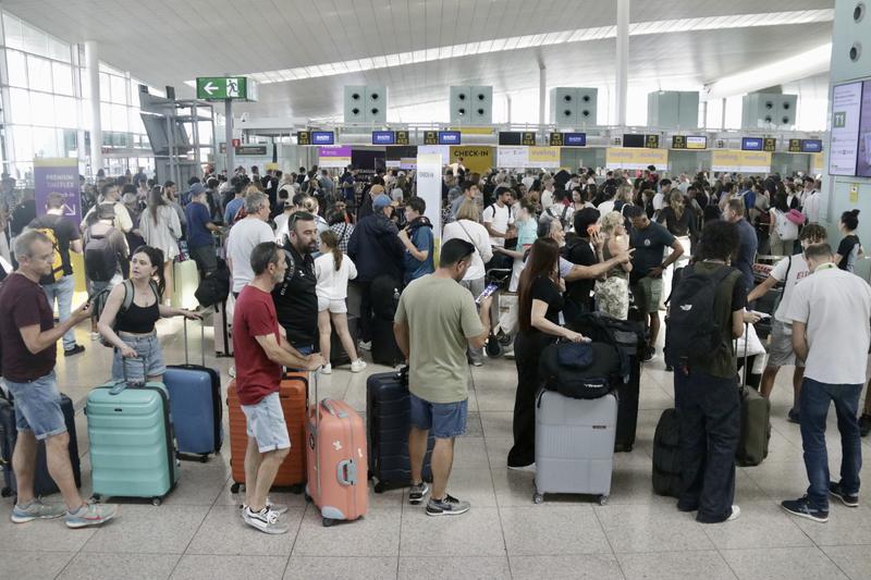 People queue at Barcelona El Prat airport on July 19, 2024 during the summer season