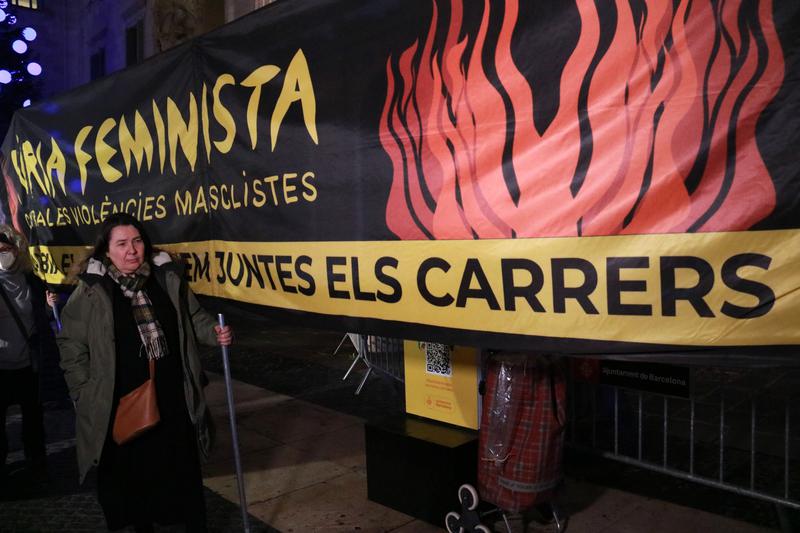 A woman holds up a banner during a rally in Barcelona against the rise of femicides in Spain
