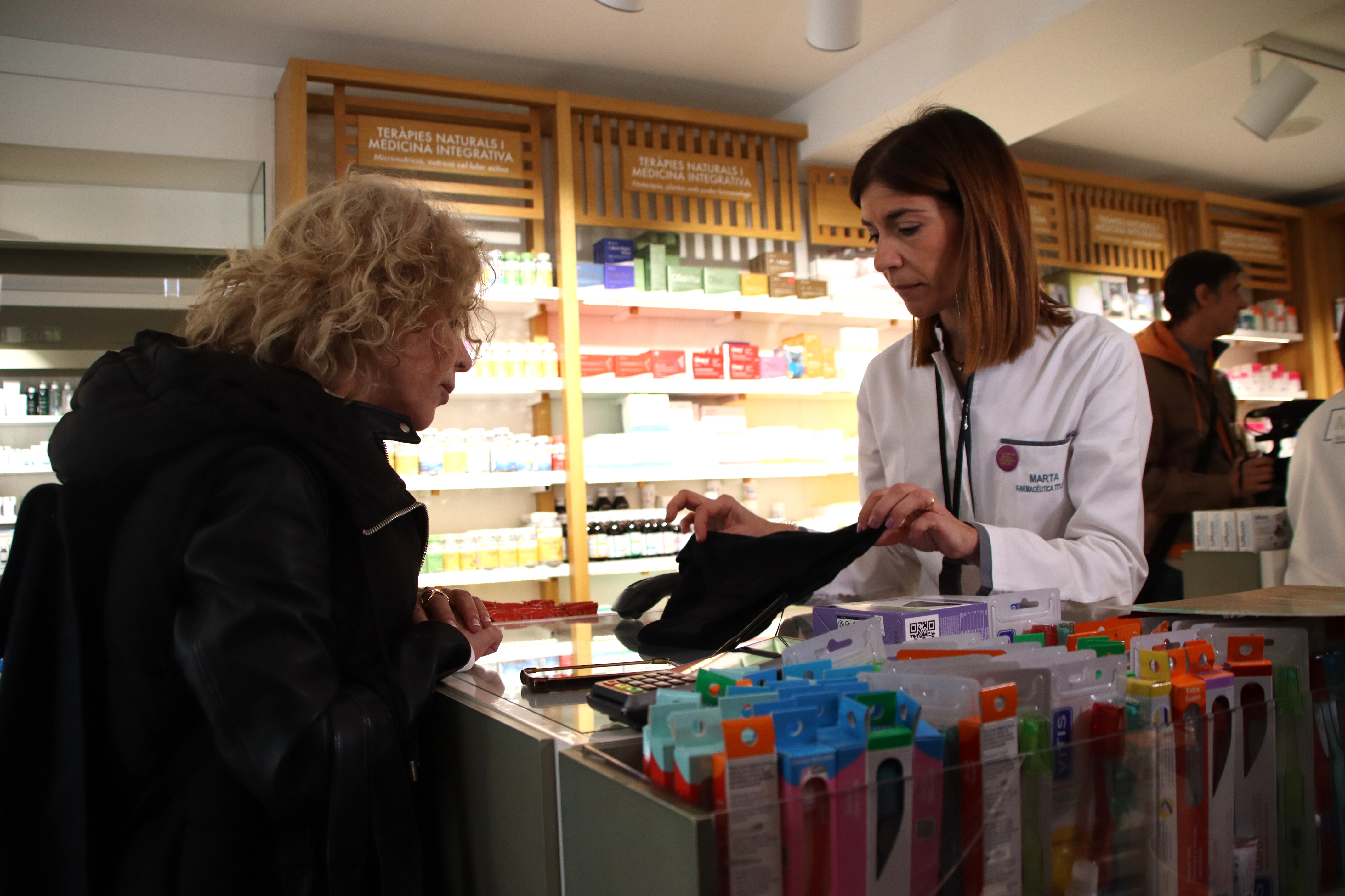 A pharmacist shows a woman a pair of absorbent underwear