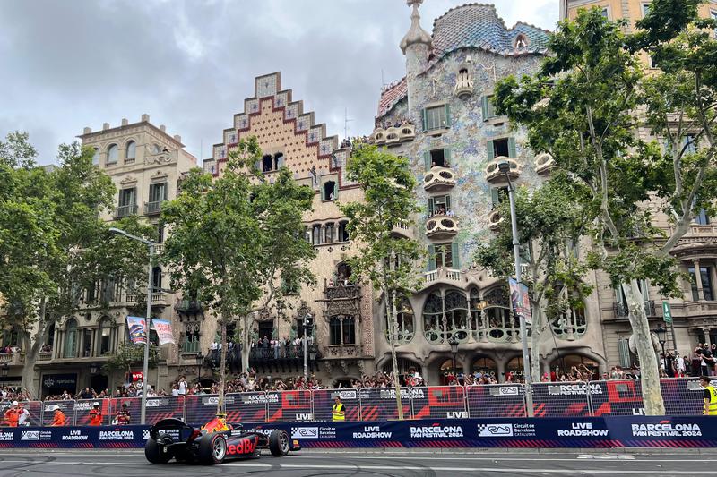 A Red Bull F1 car drives in front of Casa Batlló on Passeig de Gràcia as part of the F1 road show event in Barcelona