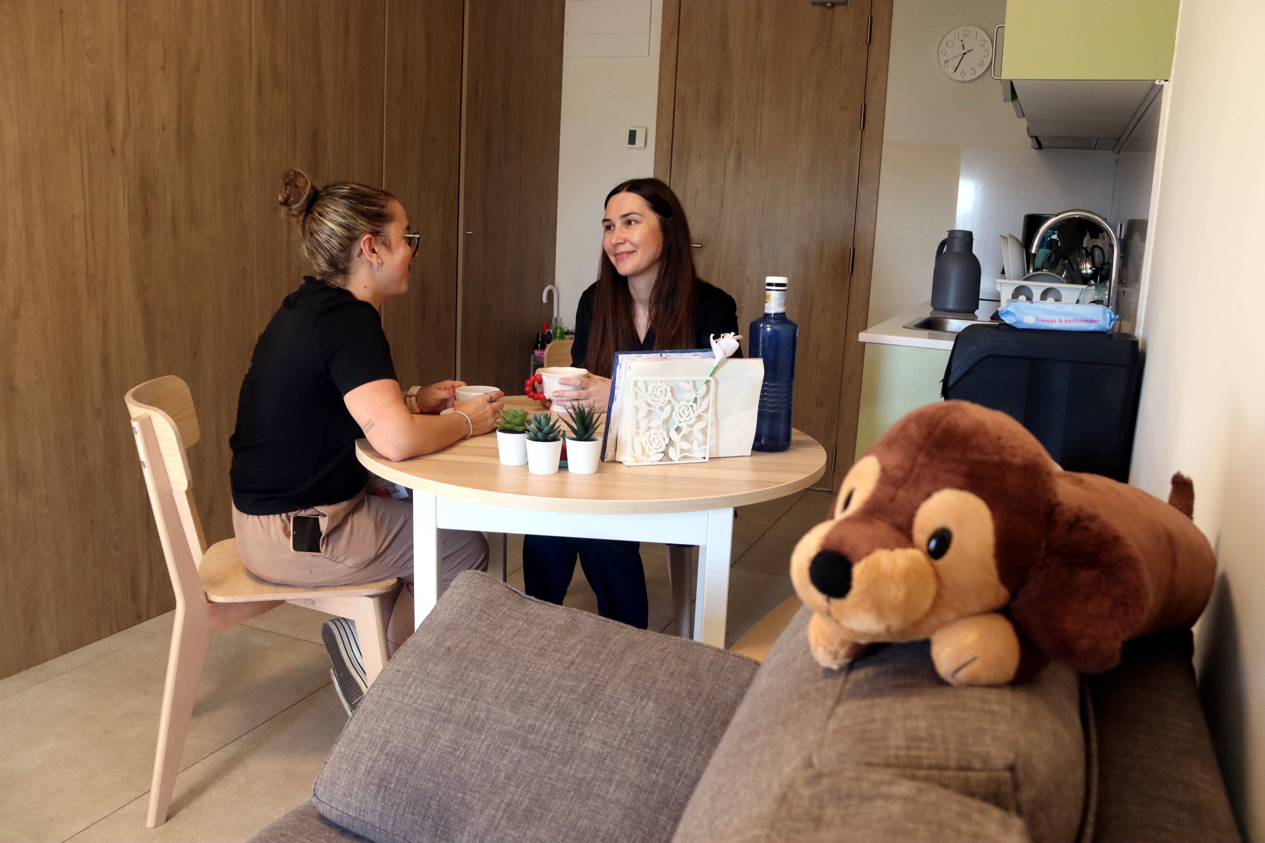 Ana chats to a social worker in her flat at the residential center