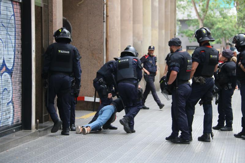 Catalan police officers removing one of the activists protesting in the interior of a Parallel avenue building aiming to prevent an eviction