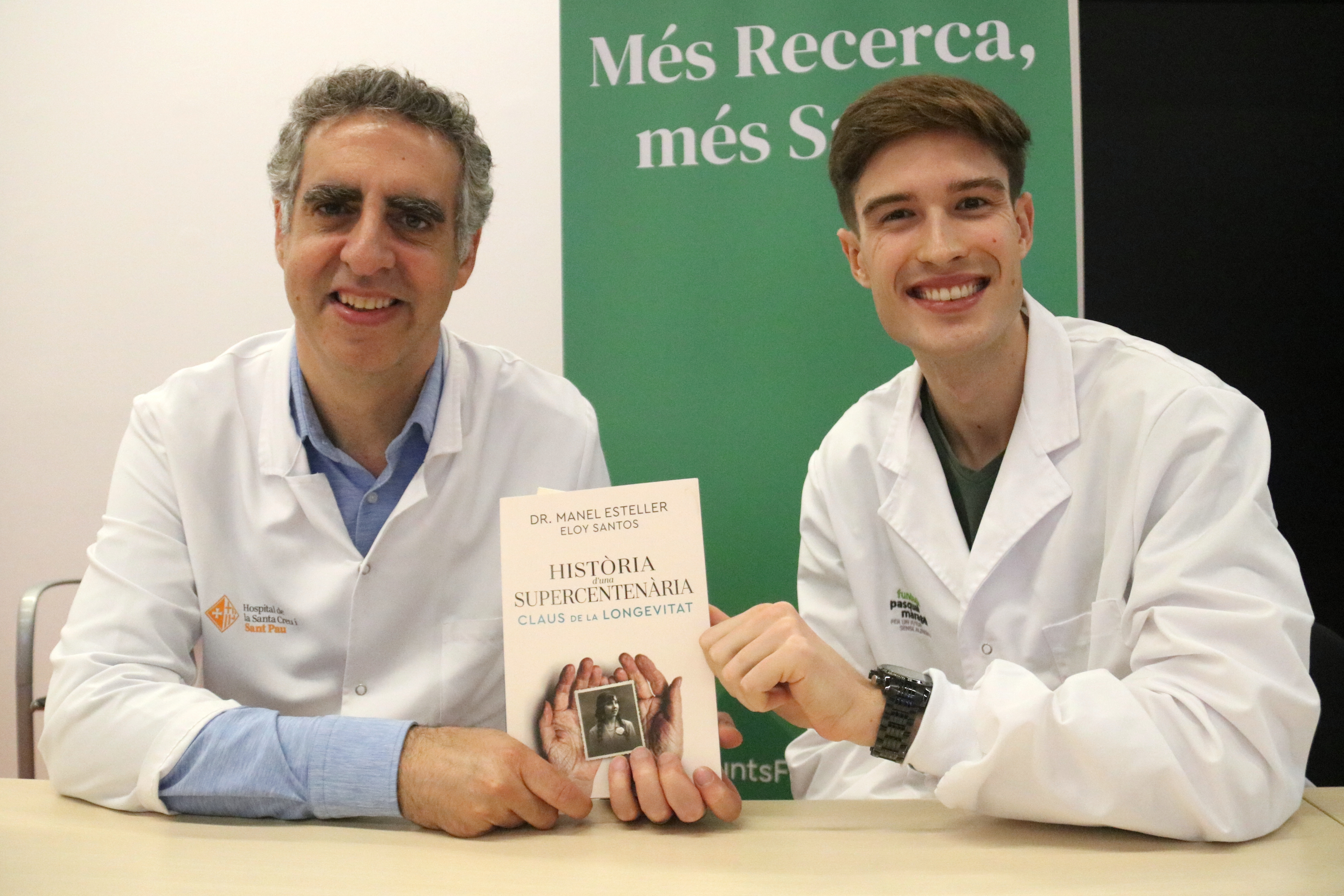 Researchers Manel Esteller and Eloy Santos, with the book they have published on the phenomenon of supercentenarians.