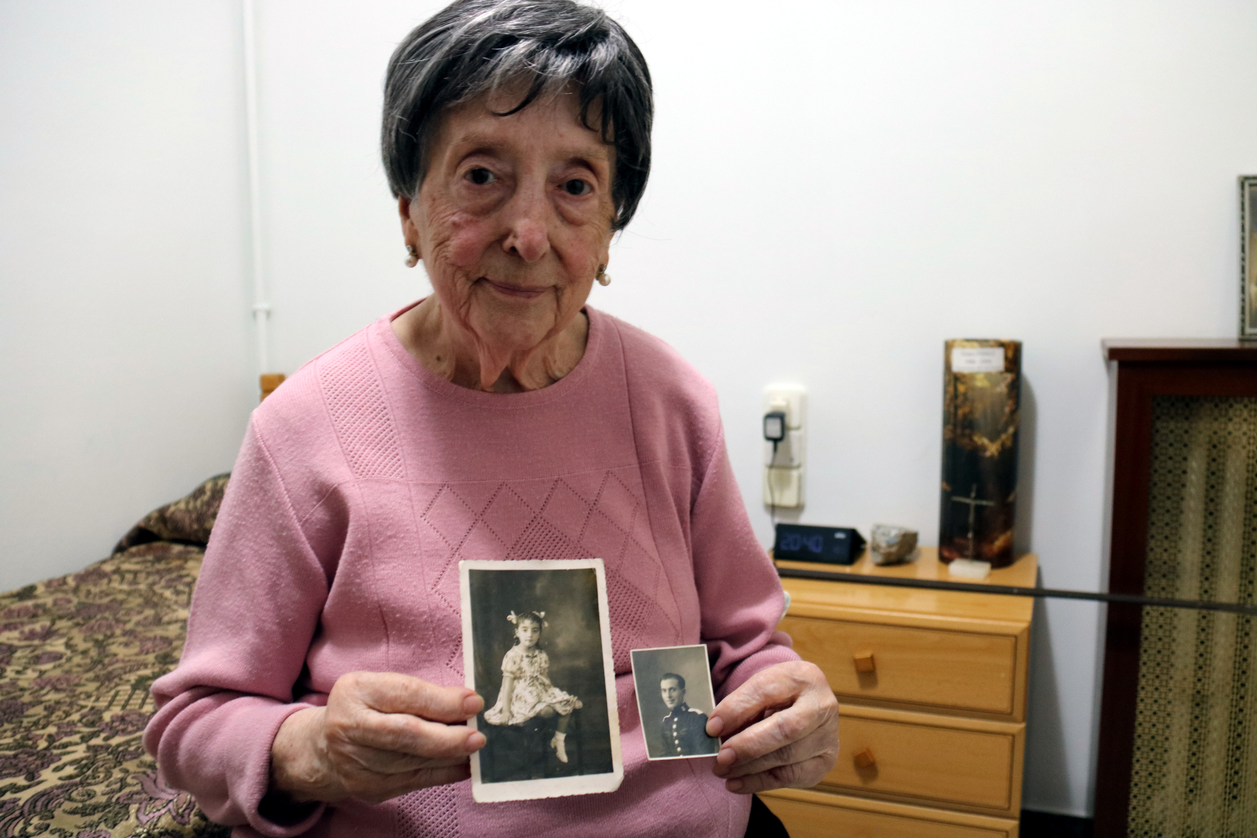 Rosario holding a picture of when she was little and of her father.