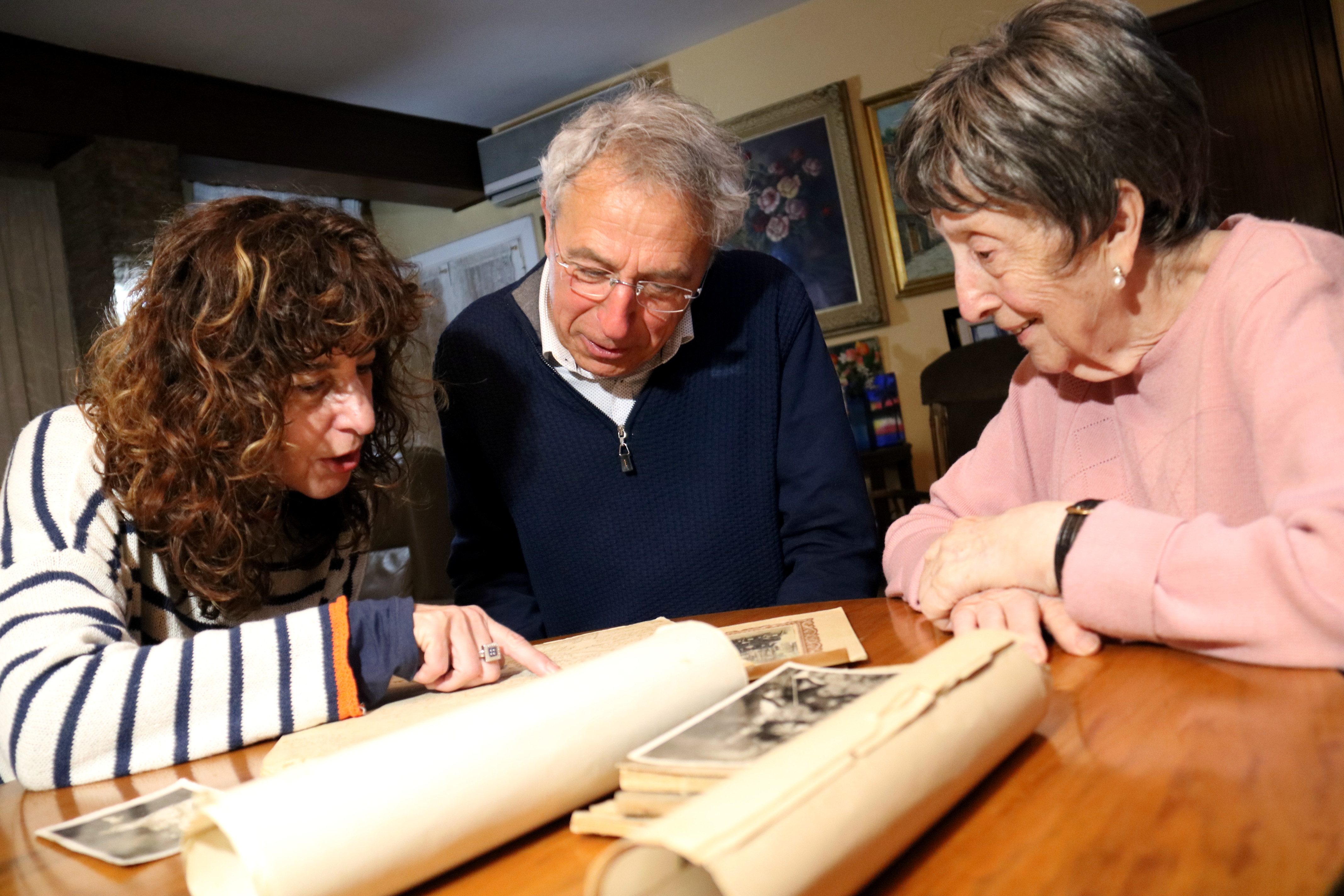 Rosario with her daughter, Dolors and Joasuim Aloy looking at historical pictures.