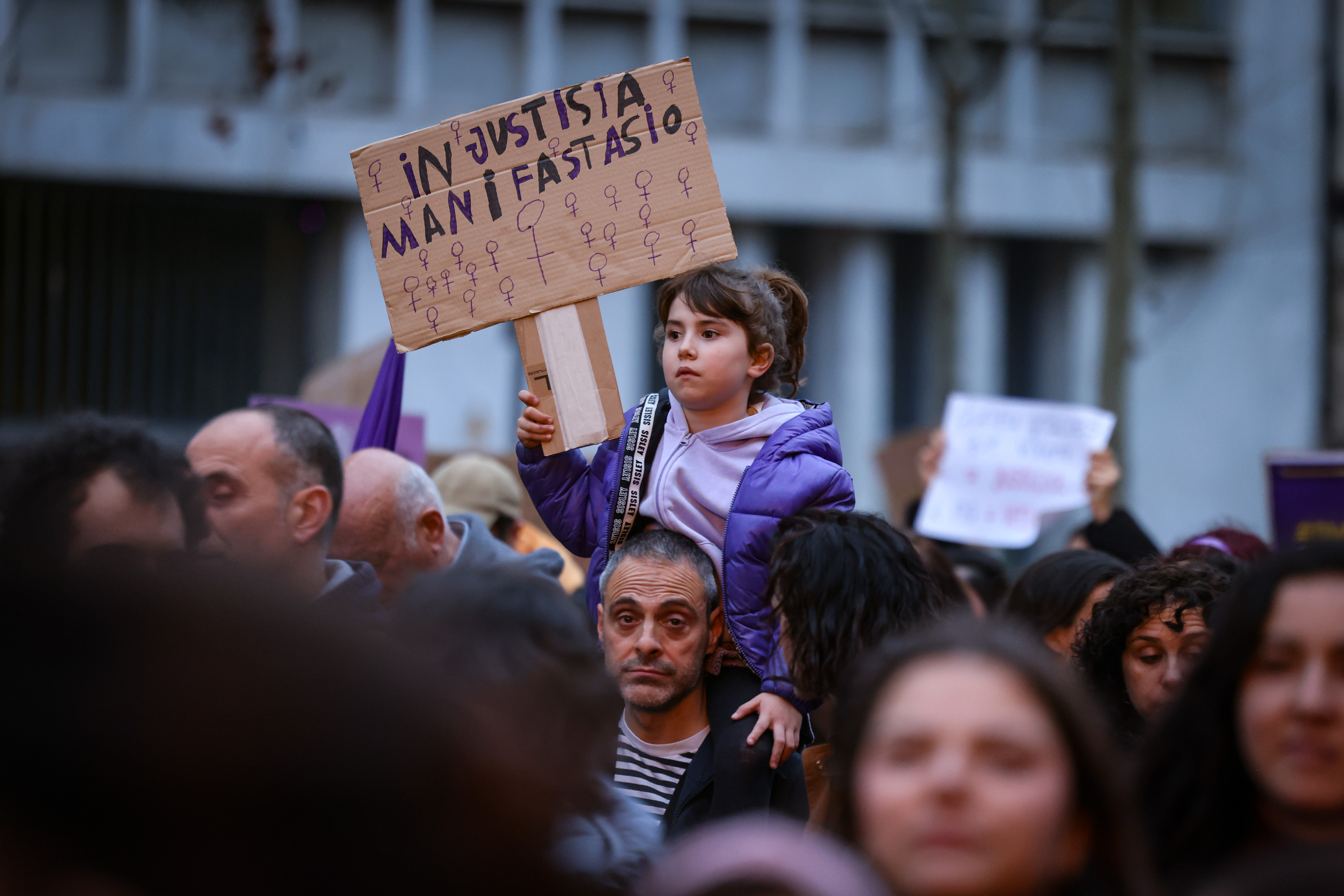 A girl carries a poster reading: 'Injustice, demonstration!' during a march on International Women's Day