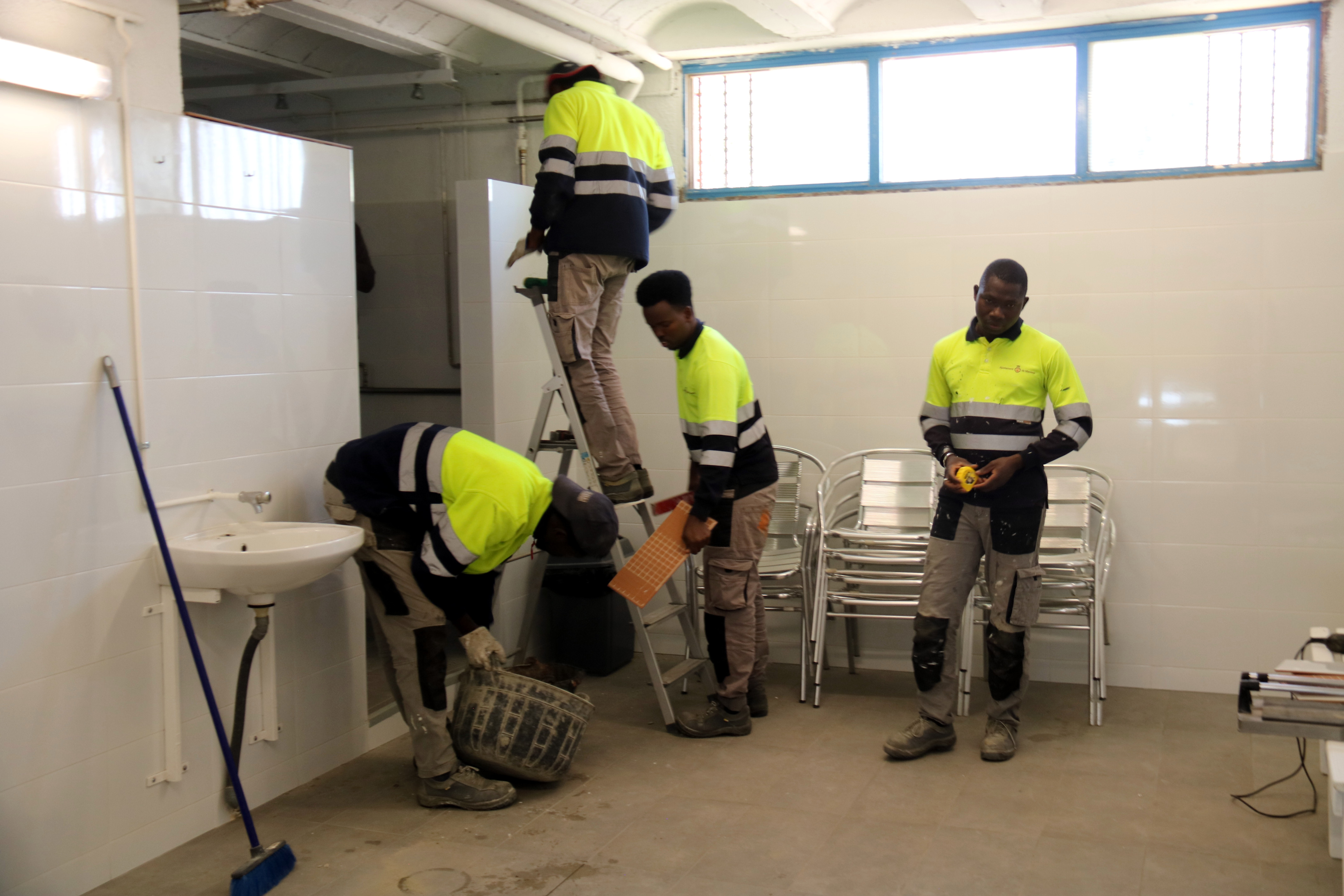 Program participants refurbishing a local football court in Manresa