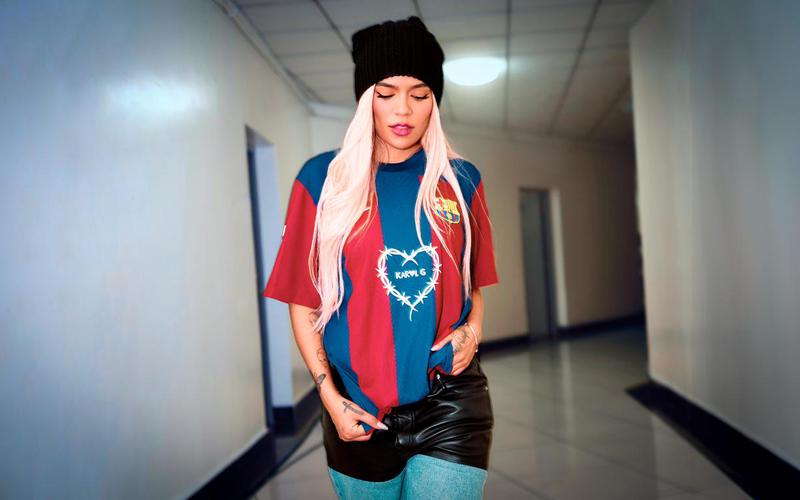 Karol G wearing a special edition of the FC Barcelona jersey with her logo printed