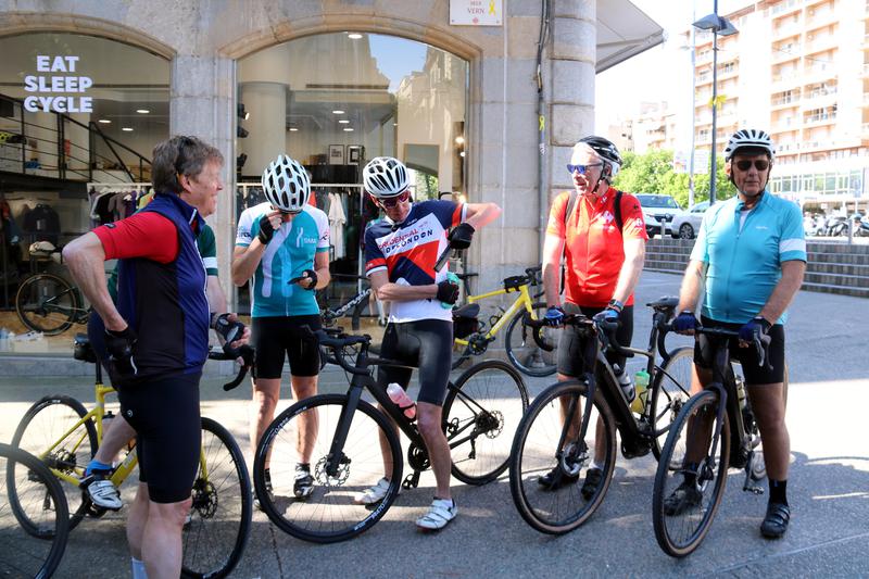 A group of cyclists prepare for a ride outside Eat Sleep Cycle in Girona