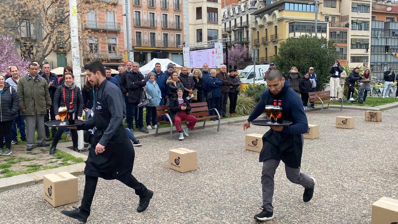 Two people competing in the Fòrum Gastronòmic's annual servers race