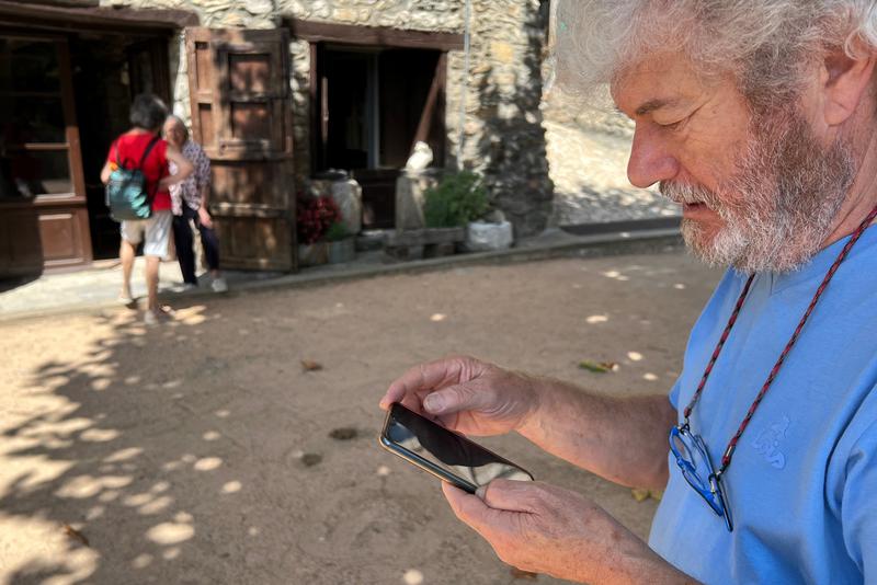 A man in Beget looking at his phone