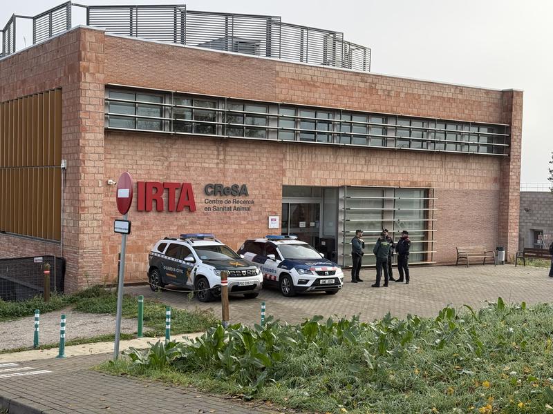 Officers from the Mossos d'Esquadra and Guardia Civil outside the IRTA-CReSA laboratory