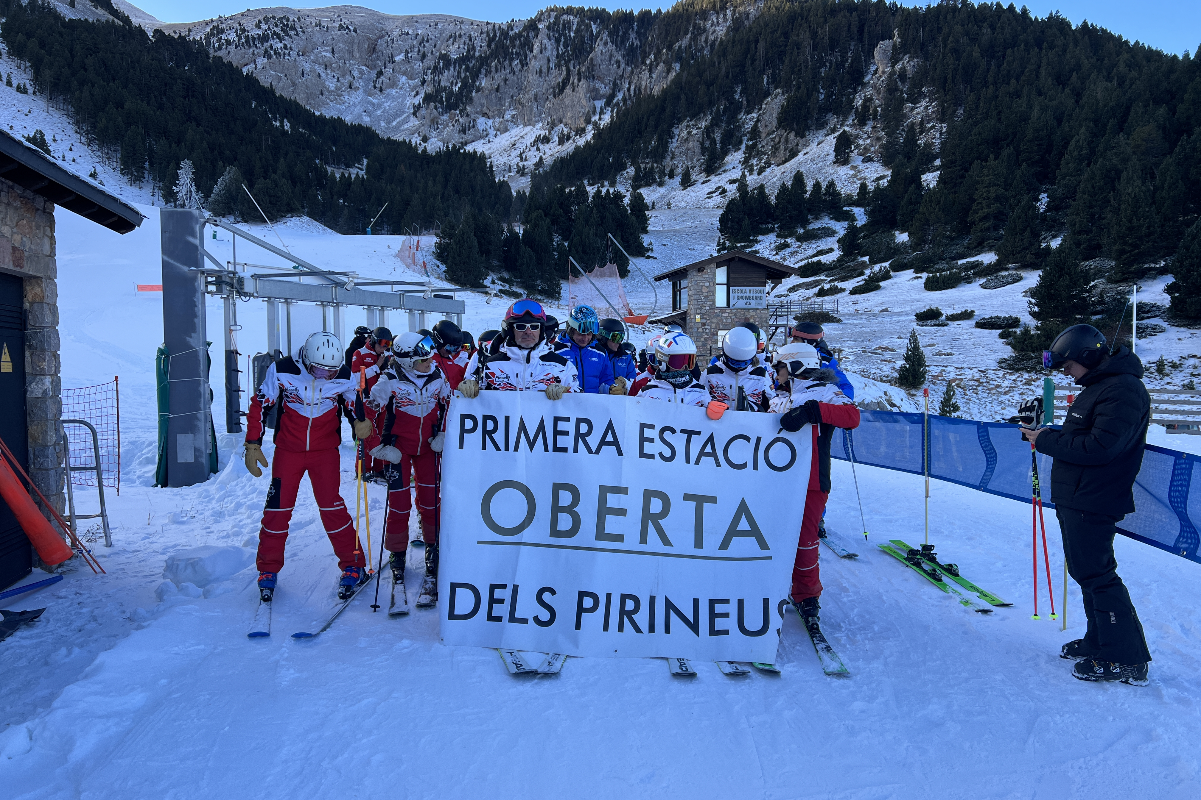 Skiers at Masella hold a banner declaring the resort as the first to open in the Pyrenees this season