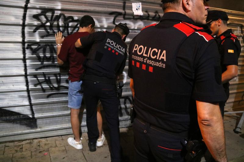 Catalan police perform a search on a person during the Tarragona Santa Tecla festivities