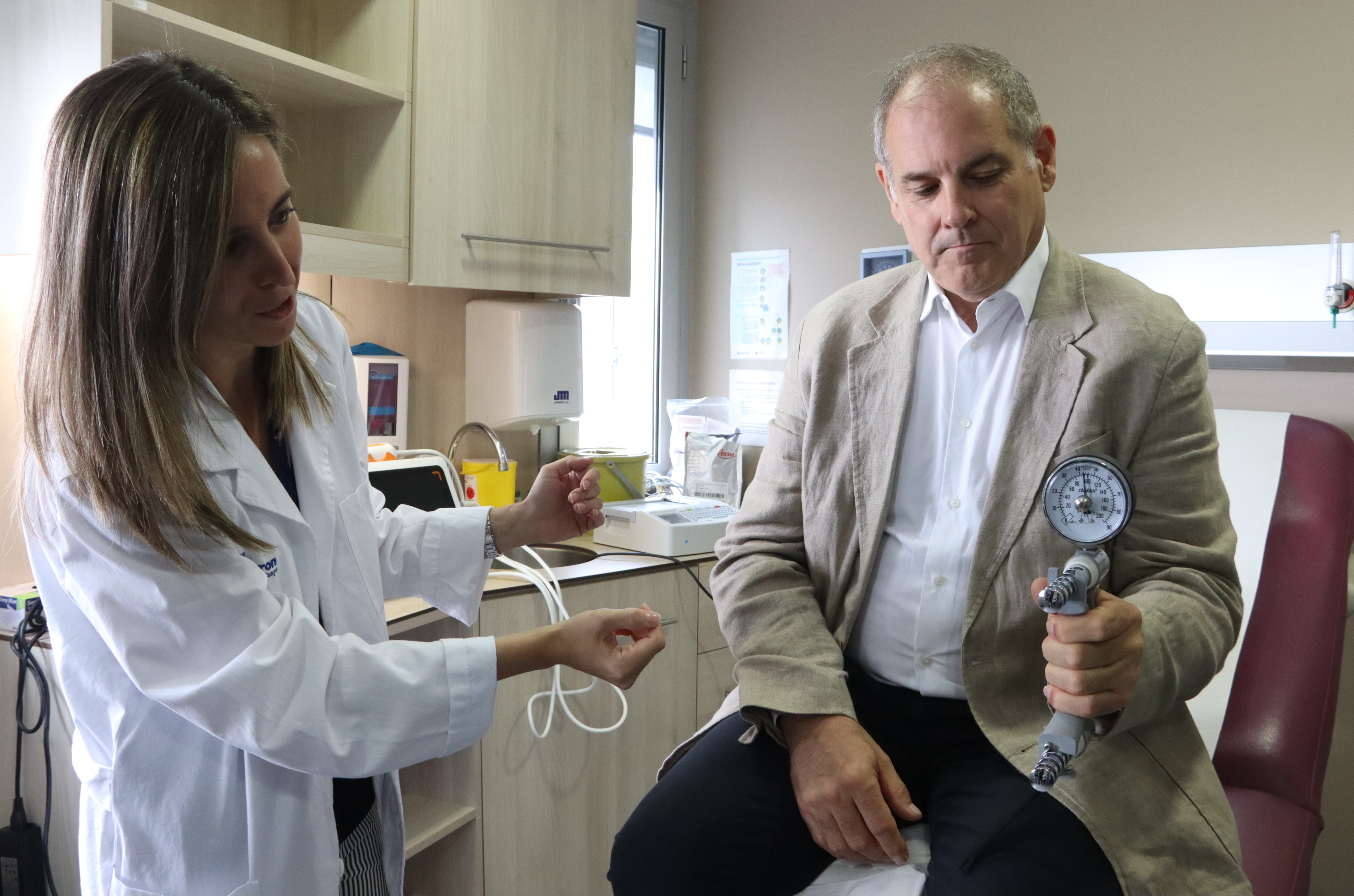 Vall d’Hebron nutritionist Marta Comas measures muscle strength in Juanjo Cortés, a patient receiving obesity treatment