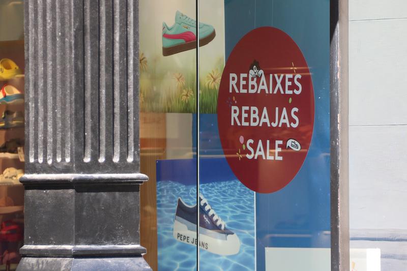 A sign announcing sales in a shop window