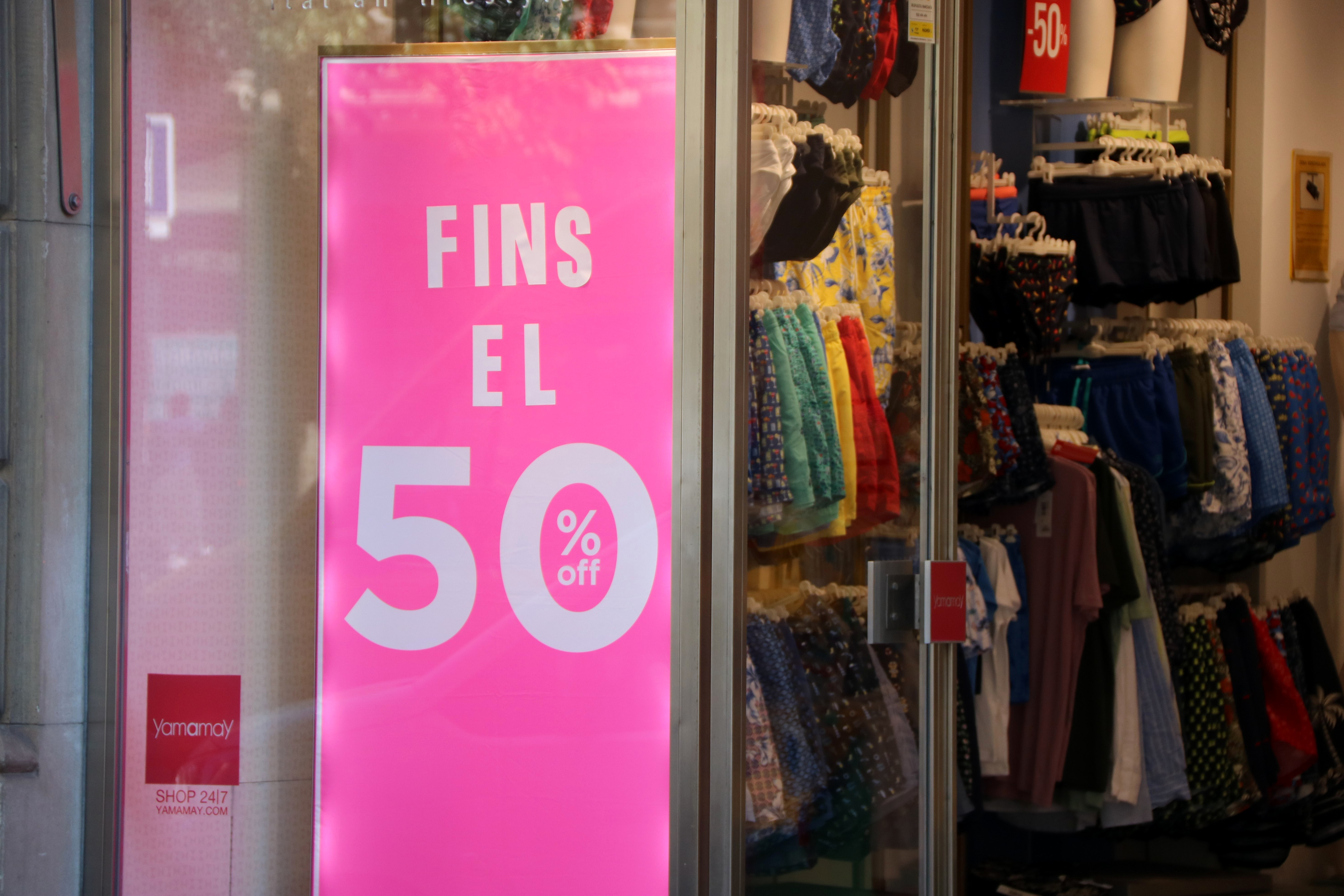 A sign advertising discounts of up to 50% in a shop window