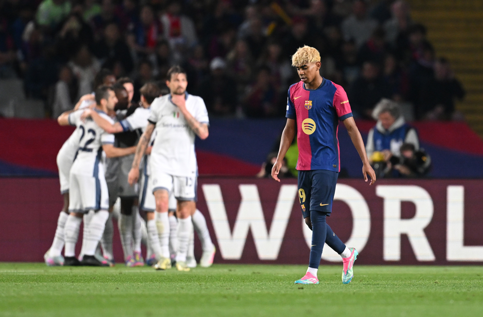 Lamine Yamal of FC Barcelona looks dejected as Denzel Dumfries of FC Internazionale celebrates scoring his team’s third goal with teammates