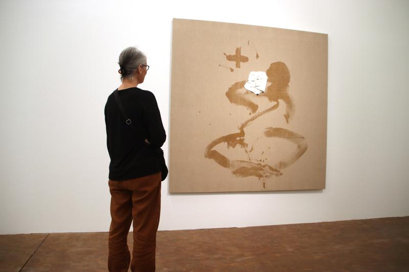 A spectator examines one of Antoni Tàpies' art pieces at the Fundació Antoni Tàpies