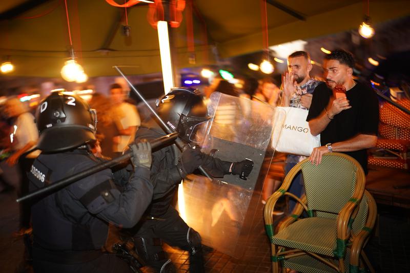 Two Mossos d'Esquadra officers charge at two protesters during the pro-Palestine demonstration in central Barcelona