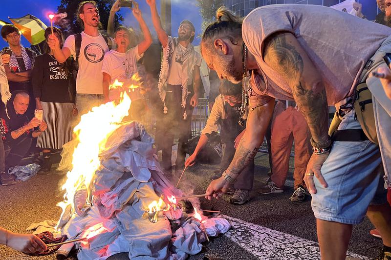 Flotilla activists burn the prison uniforms they wore while being held in Israel