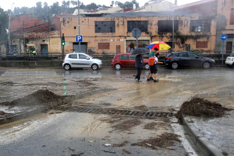 People walking around Terrassa during a storm that caused floods around the city on June 13, 2023
