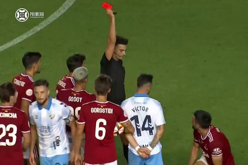 Referee Eder Mallo Fernández sends off a Nàstic player in the promotion match against Málaga