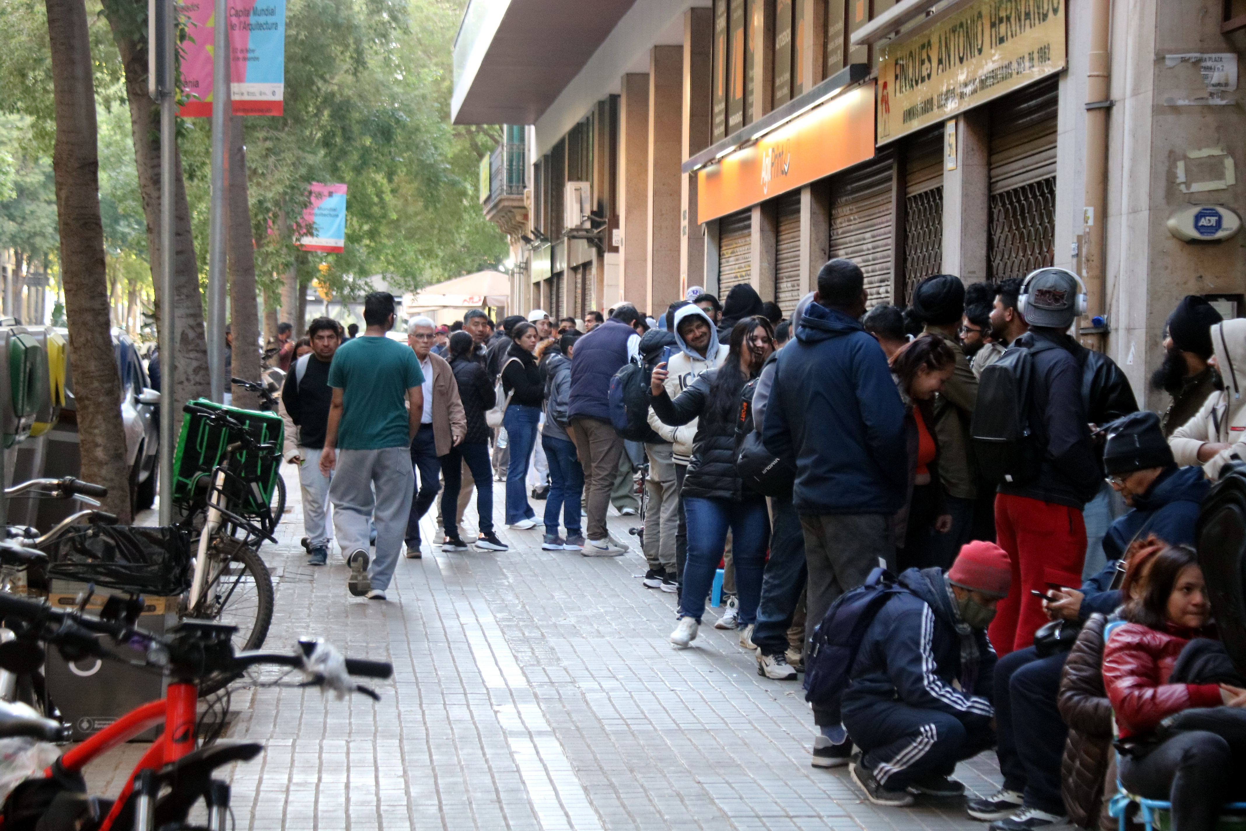 People queue on Carrer Diputació during Spain’s migrant regularisation programme