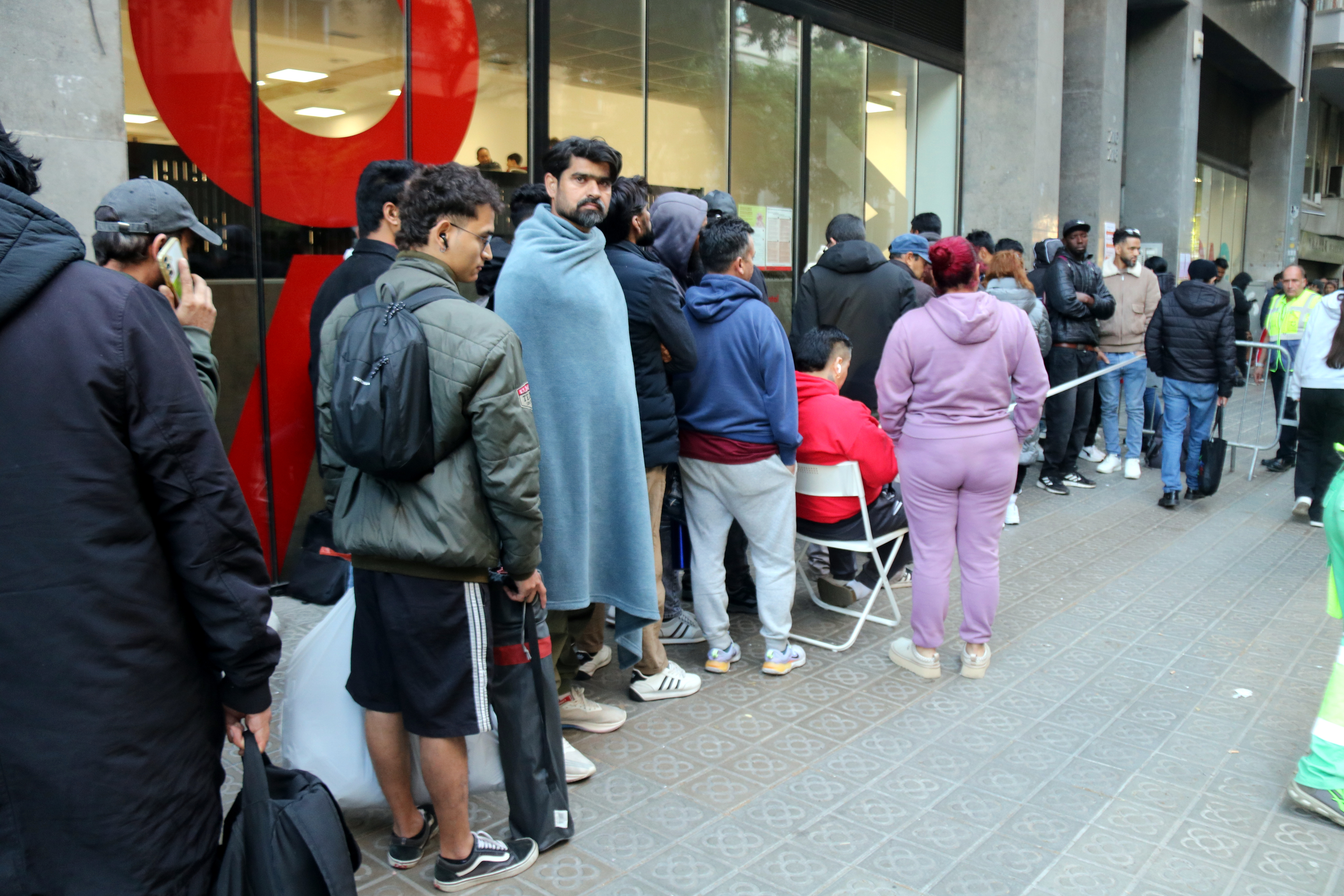 People queue outside Barcelona's OAC Monumental office during Spain’s migrant regularisation programme