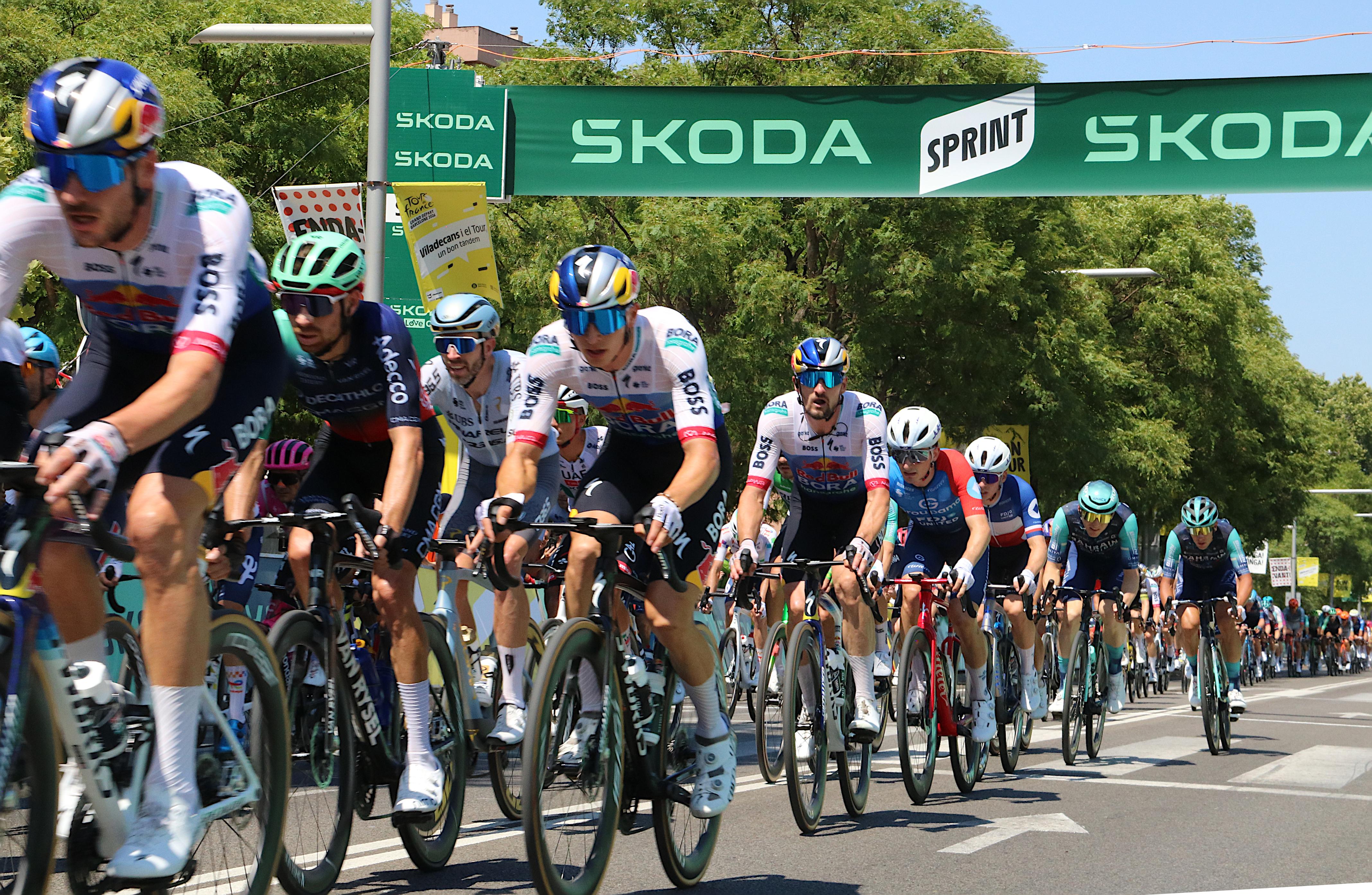 Cyclists crossing the sprint finish line in Viladecans in the second stage of the Tour.