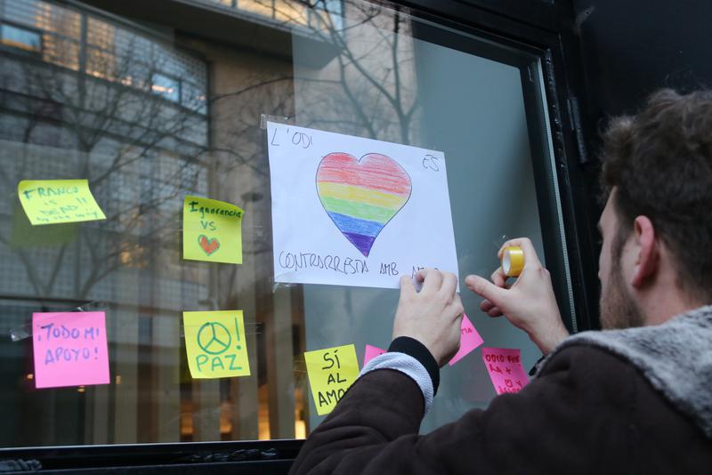 A person sticks a message of solidarity onto an LGBT center in Barcelona following an attack in 2019