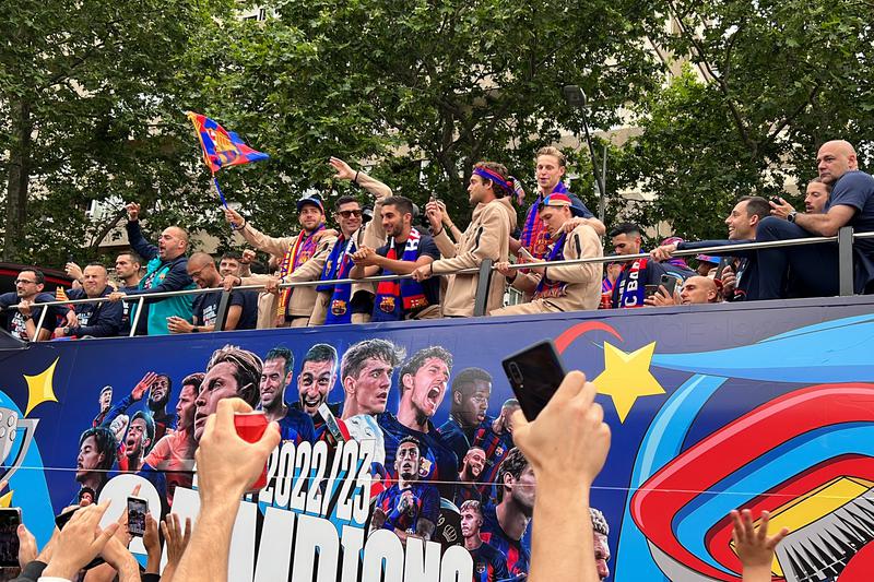 Barça players wave to fans during their victory parade