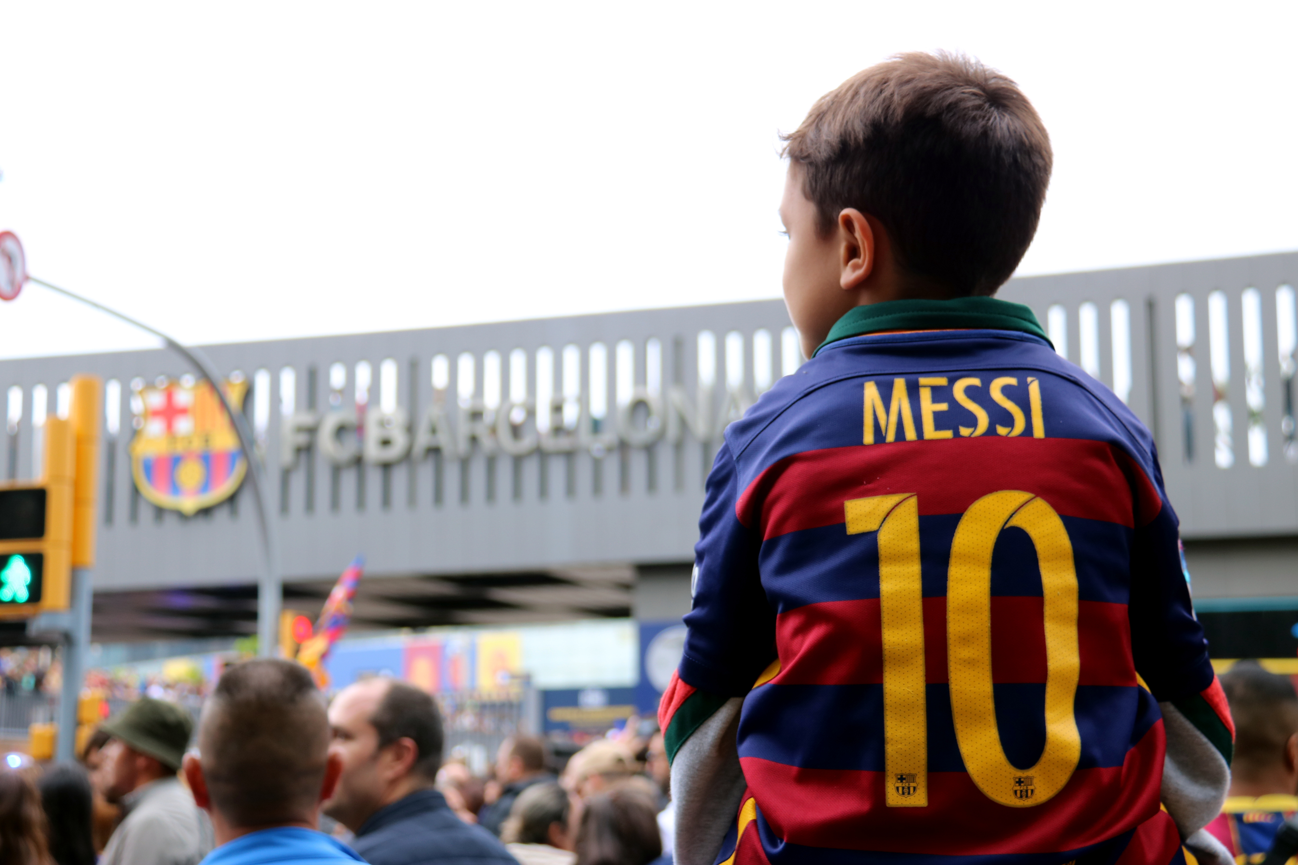 A boy wearing a Barcelona shirt with Messi on the back