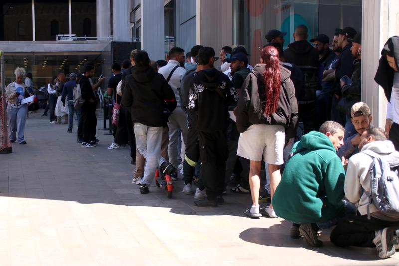 Several people are waiting in line at the Citizen Service Office (OAC) in Plaça Sant Miquel in Barcelona